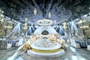 A grand hall with a central stage, ornate chandeliers, and a circular seating arrangement. - Yulin Hotel (Yulin)