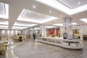 A modern hotel lobby with a central island, seating areas, and a high ceiling with recessed lighting. - Yulin Hotel (Yulin)