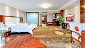 A hotel room with two beds, a dining table, a sofa, a TV, and a large window. - Yulin Hotel (Yulin)