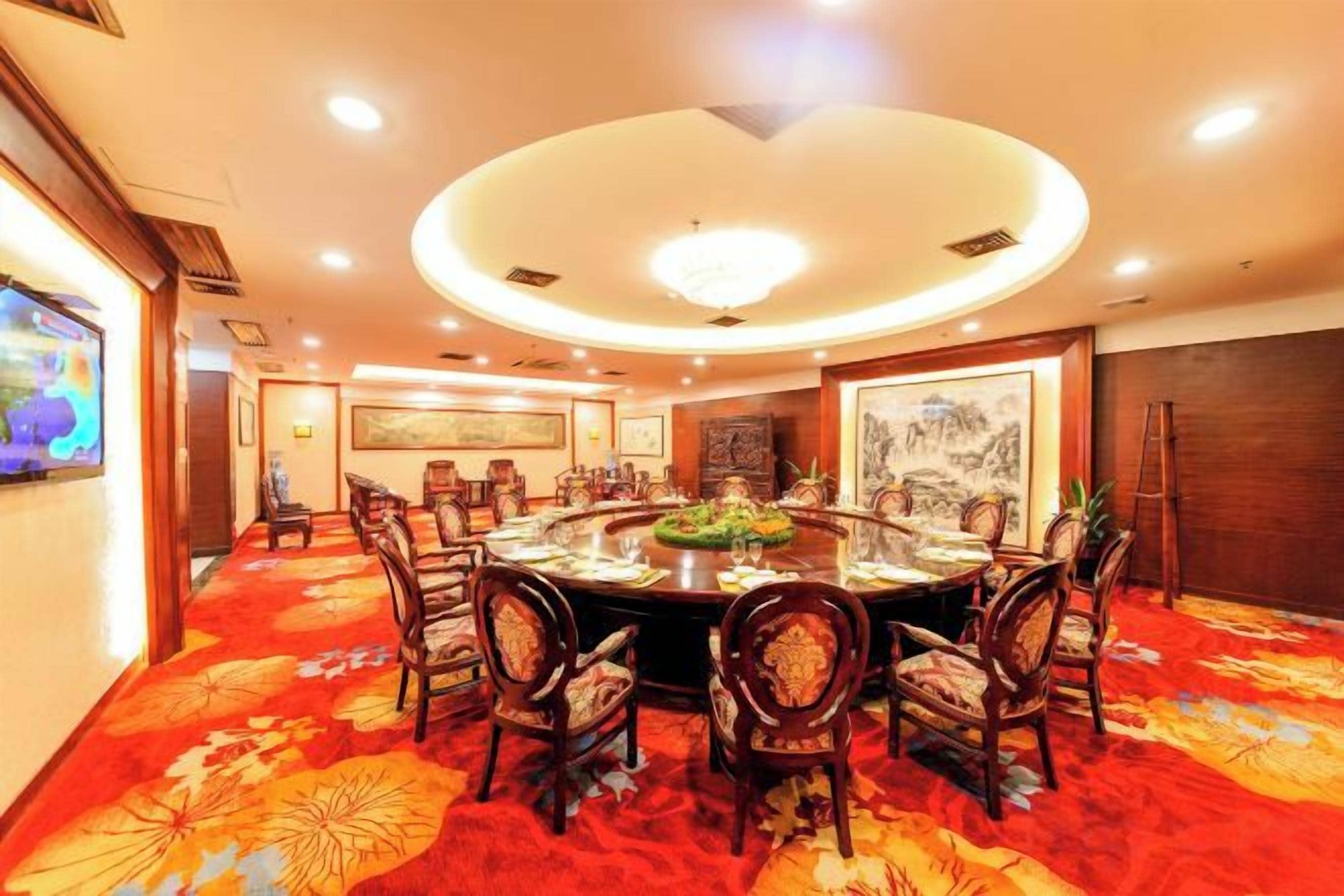 A conference room with a round table, chairs, and a carpeted floor.