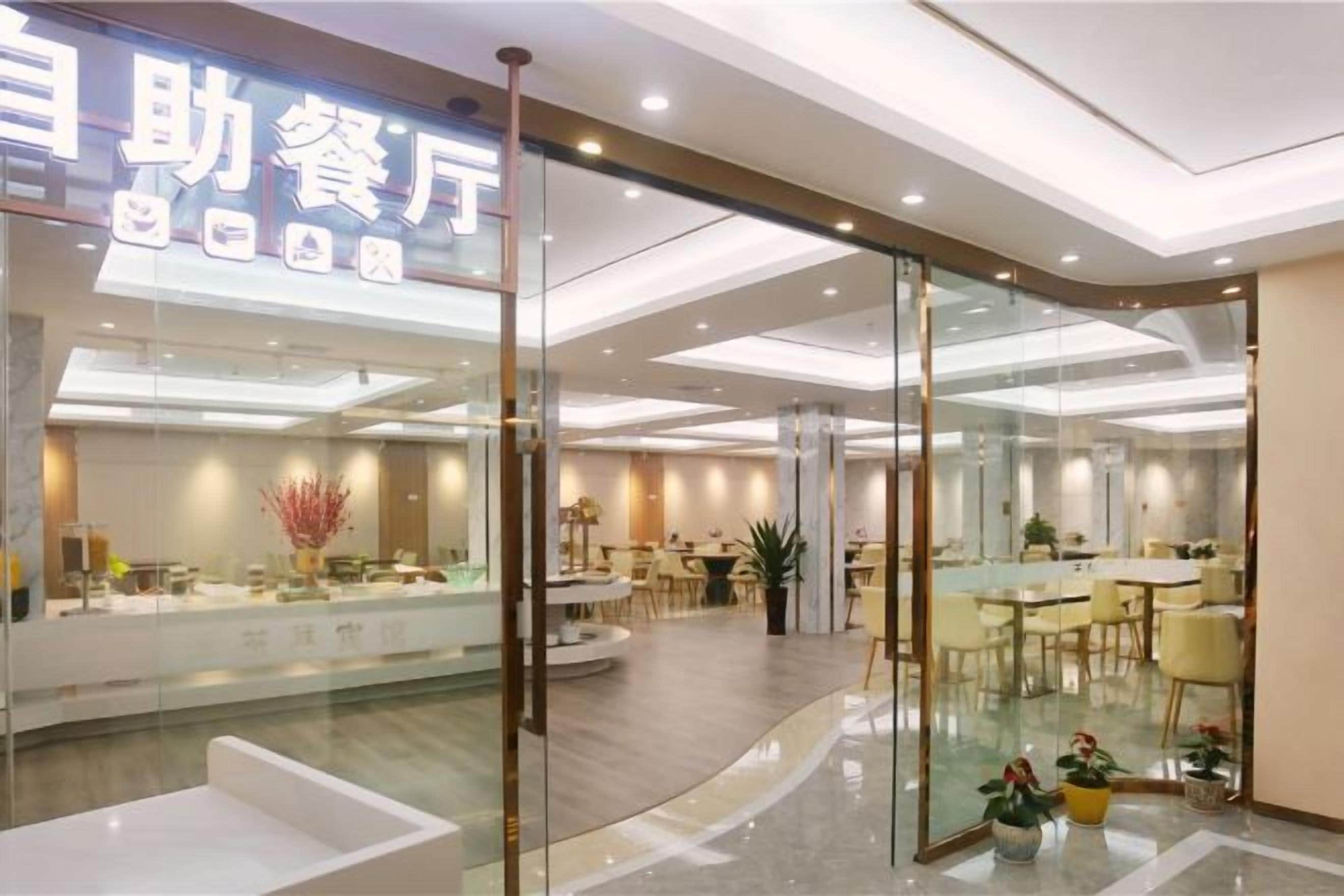 Un restaurante moderno con un separador de vidrio, asientos en el interior y una zona de mostrador visible.