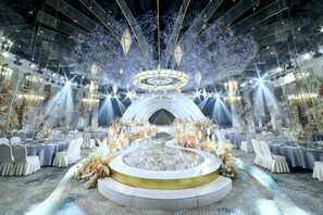 A grand hall with a central stage, ornate chandeliers, and a circular seating arrangement. - Yulin Hotel (Yulin)