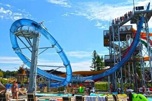 Um parque aquático com um grande escorregador azul, área de piscina e uma plataforma de observação.