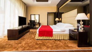 Une chambre d’hôtel moderne équipée d’un grand lit, d’une télévision à écran plat, d’un bureau et d’un miroir.