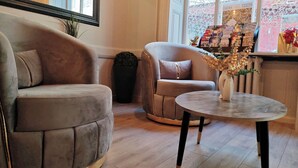 A modern living room with a round sofa, a smaller armchair, and a coffee table. - Urban Style Hotellerie du Cheval Noir (Saint-Etienne)