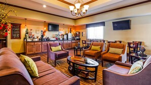 A spacious living area with leather sofas, armchairs, and a coffee table. A kitchen area with modern appliances is visible in the background. - Best Western Plus Seminole Hotel & Suites (Seminole)