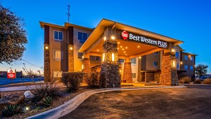 A Best Western Plus hotel with a stone facade, multiple windows, and a well-lit entrance. - Best Western Plus Seminole Hotel & Suites (Seminole)