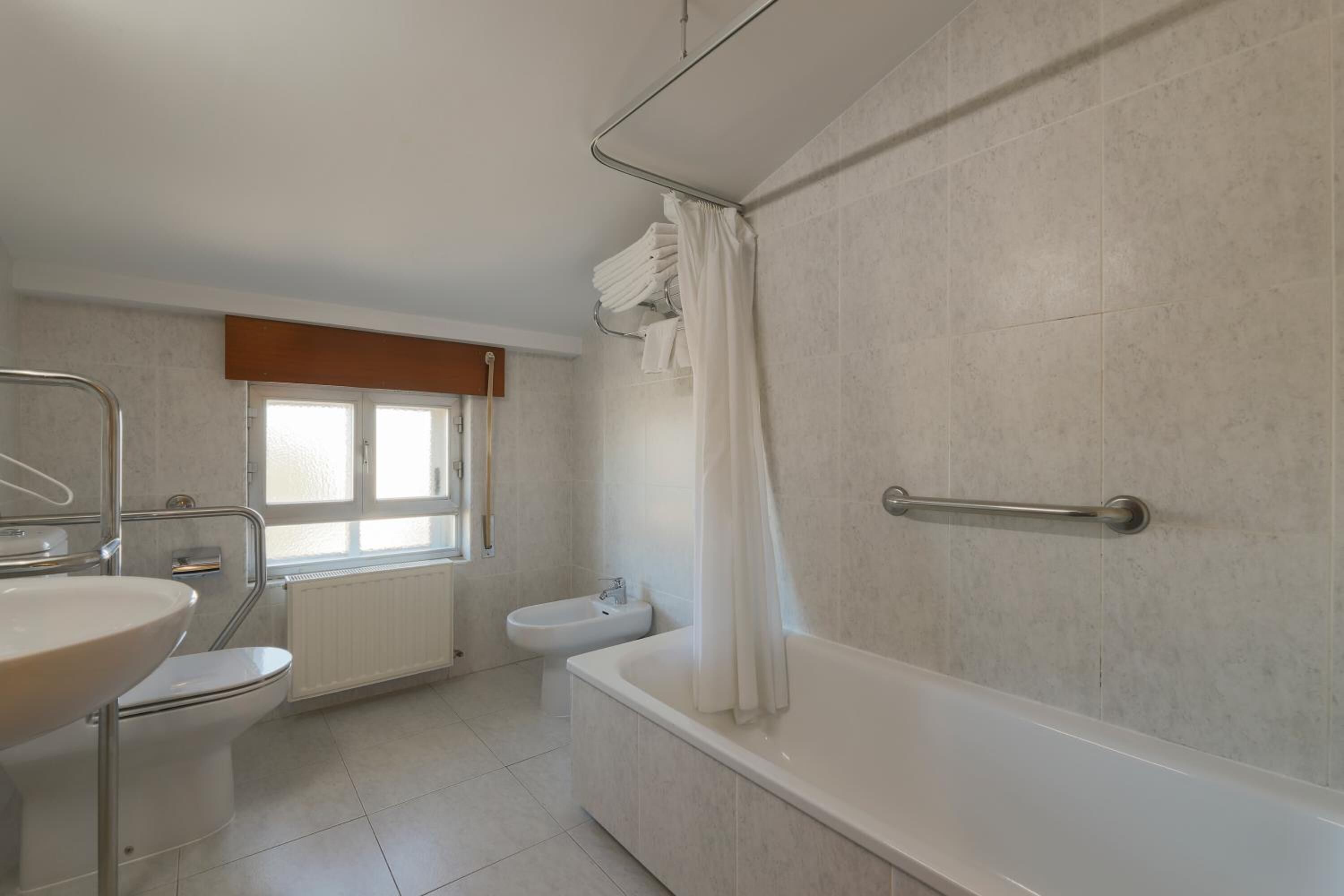 Une salle de bain moderne avec une baignoire, des toilettes et un lavabo.