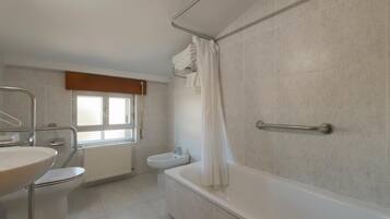 Une salle de bain moderne avec une baignoire, des toilettes et un lavabo.