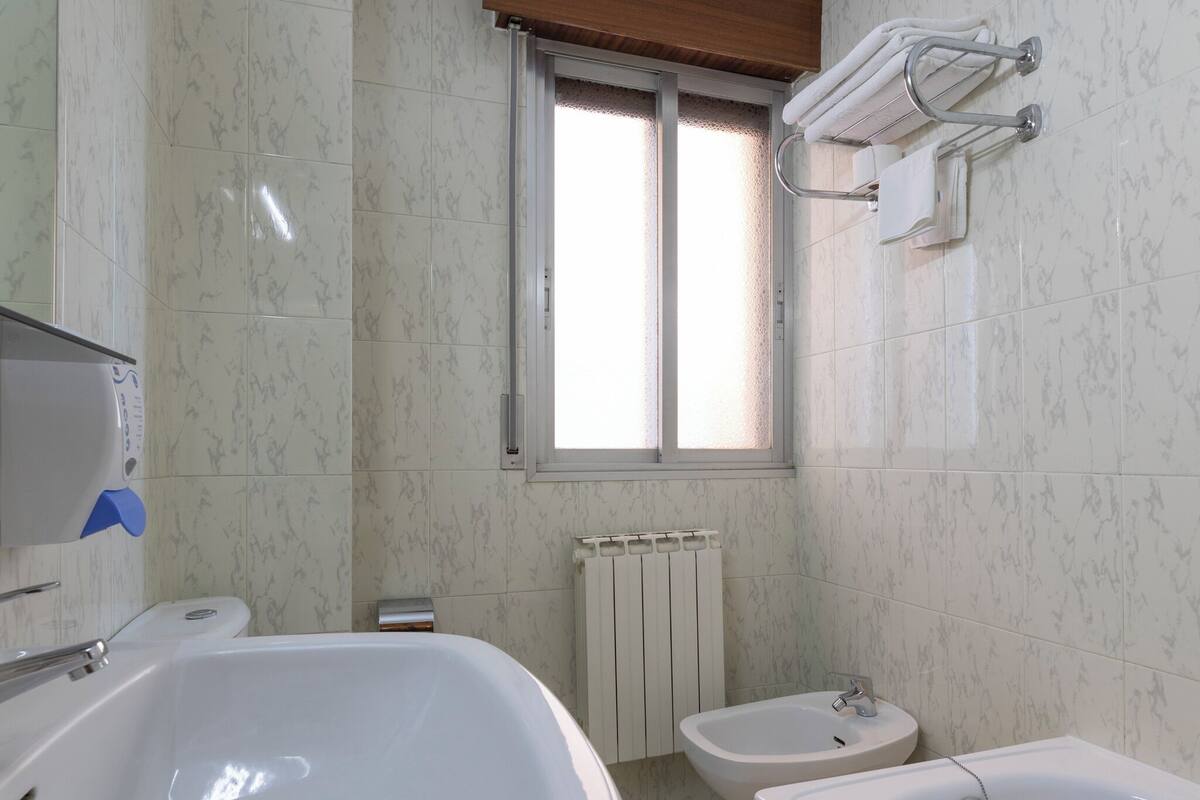 A bathroom with a large sink, a bathtub, and a toilet.