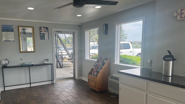 A modern kitchen with a black countertop, white cabinets, and a large window. - Motel 6 Saint George, SC – I-95 (St. George)