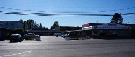 Un estacionamiento con varios automóviles y un edificio que dice 'Westward Inn & Suites'.