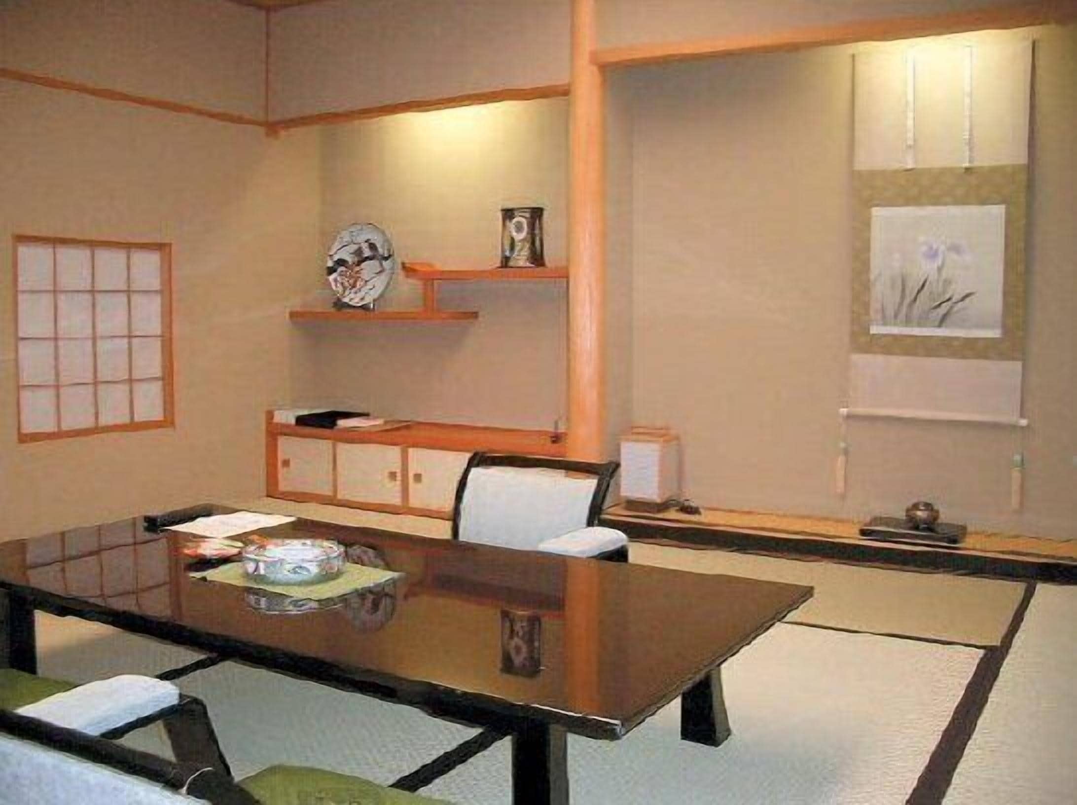 A traditional Japanese-style room with tatami mat flooring, a low wooden table, and a shoji screen.