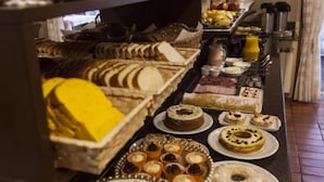 A buffet with various baked goods, pastries, and desserts. - Pousada Águia Branca (Gramado)