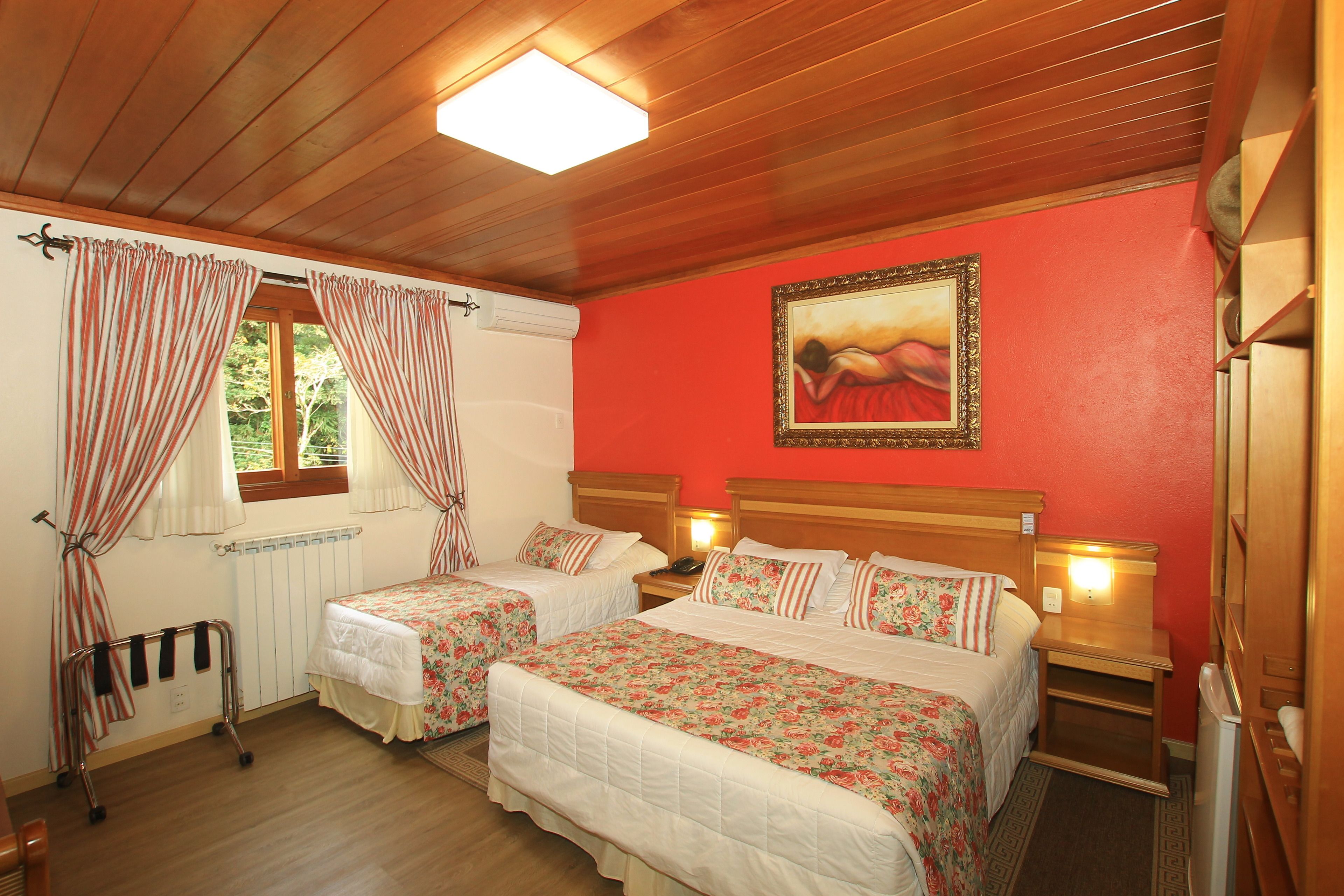 Habitación de hotel con dos camas, un cuadro en la pared y una ventana con cortinas.