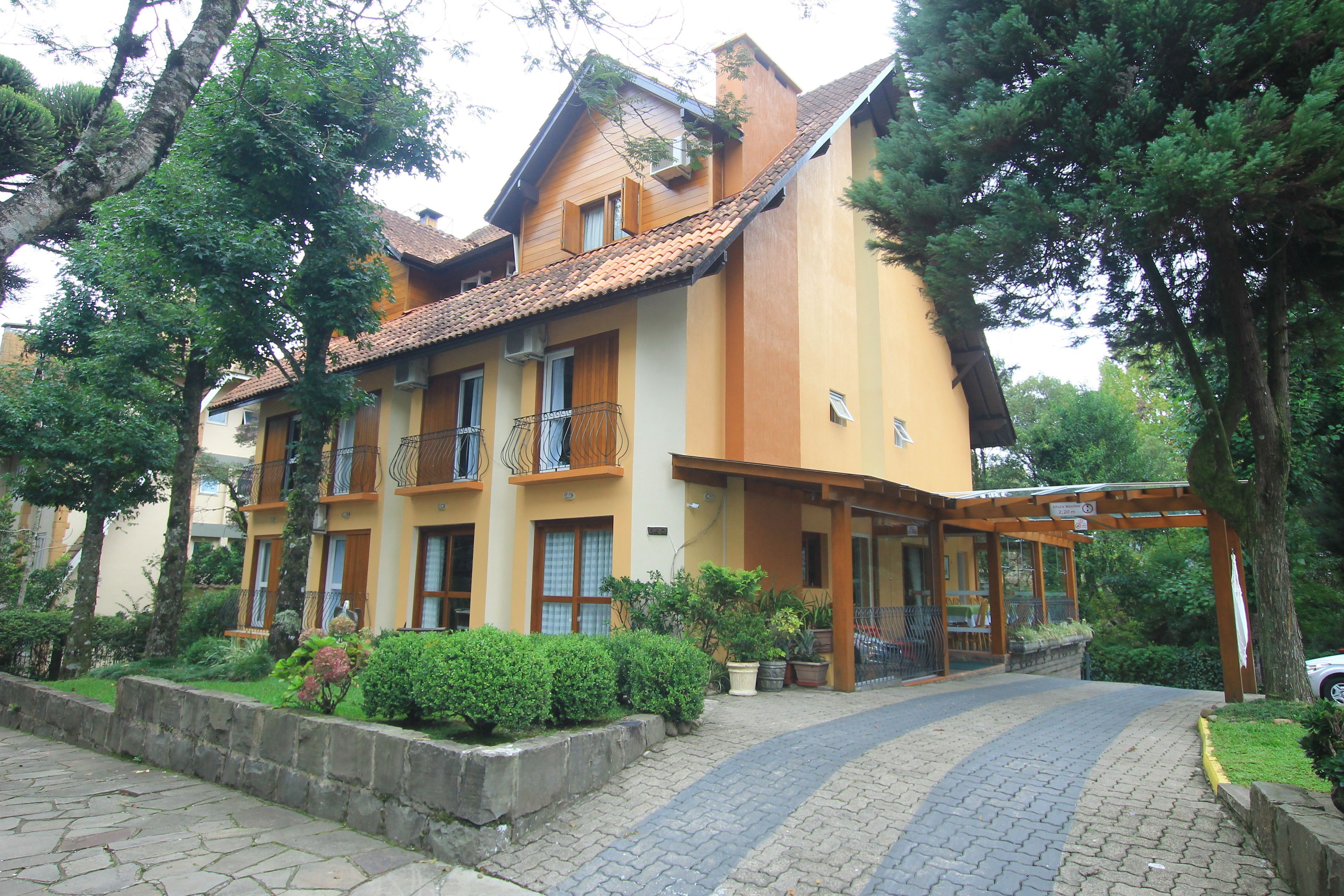 A two-story building with a tiled roof, a balcony on the second floor, and a covered entrance area.