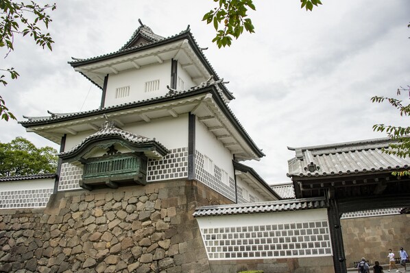 Un castillo japonés tradicional con varios niveles y base de piedra.