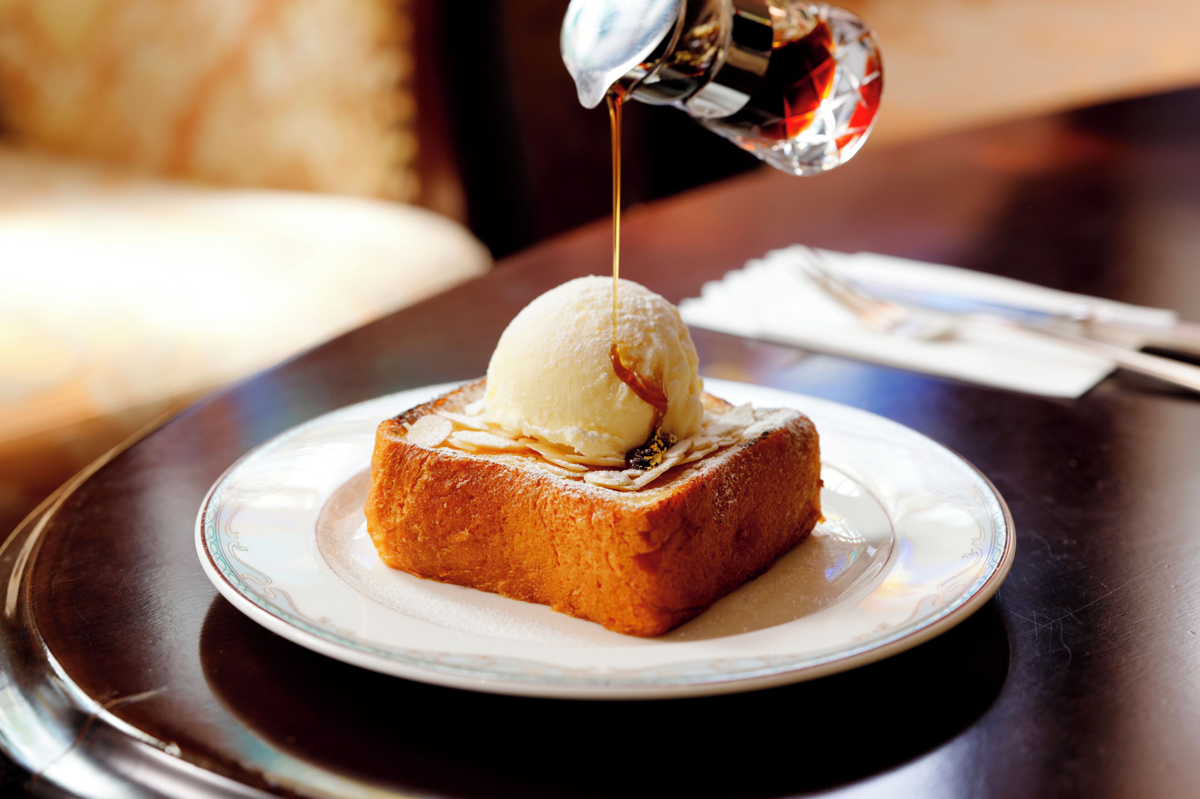Postre en un plato con almíbar siendo vertido.