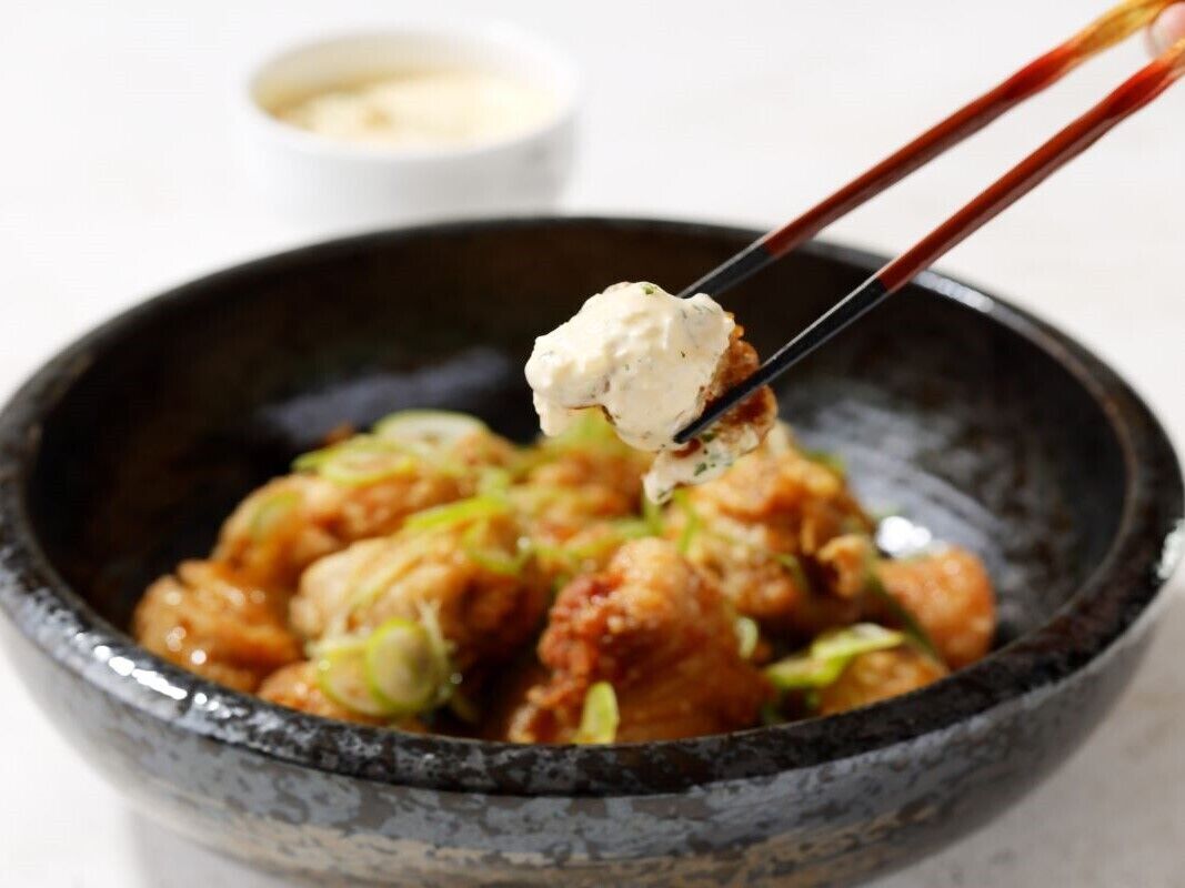 A bowl of fried chicken with a dipping sauce.