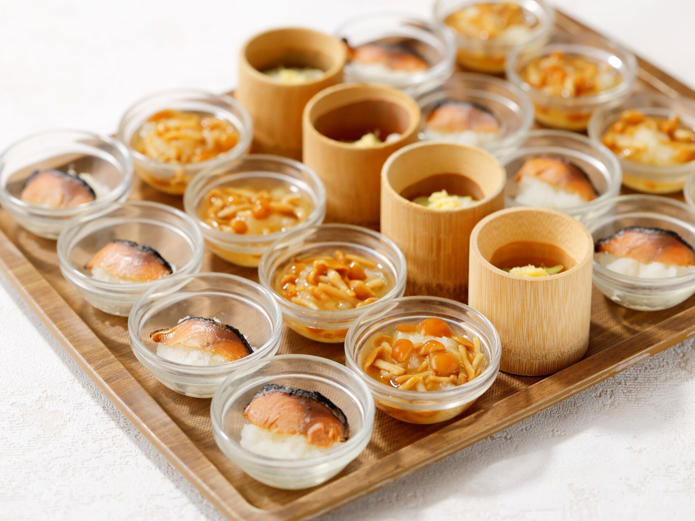 A tray of food items, including small bowls and cups, likely containing various dishes and sauces.