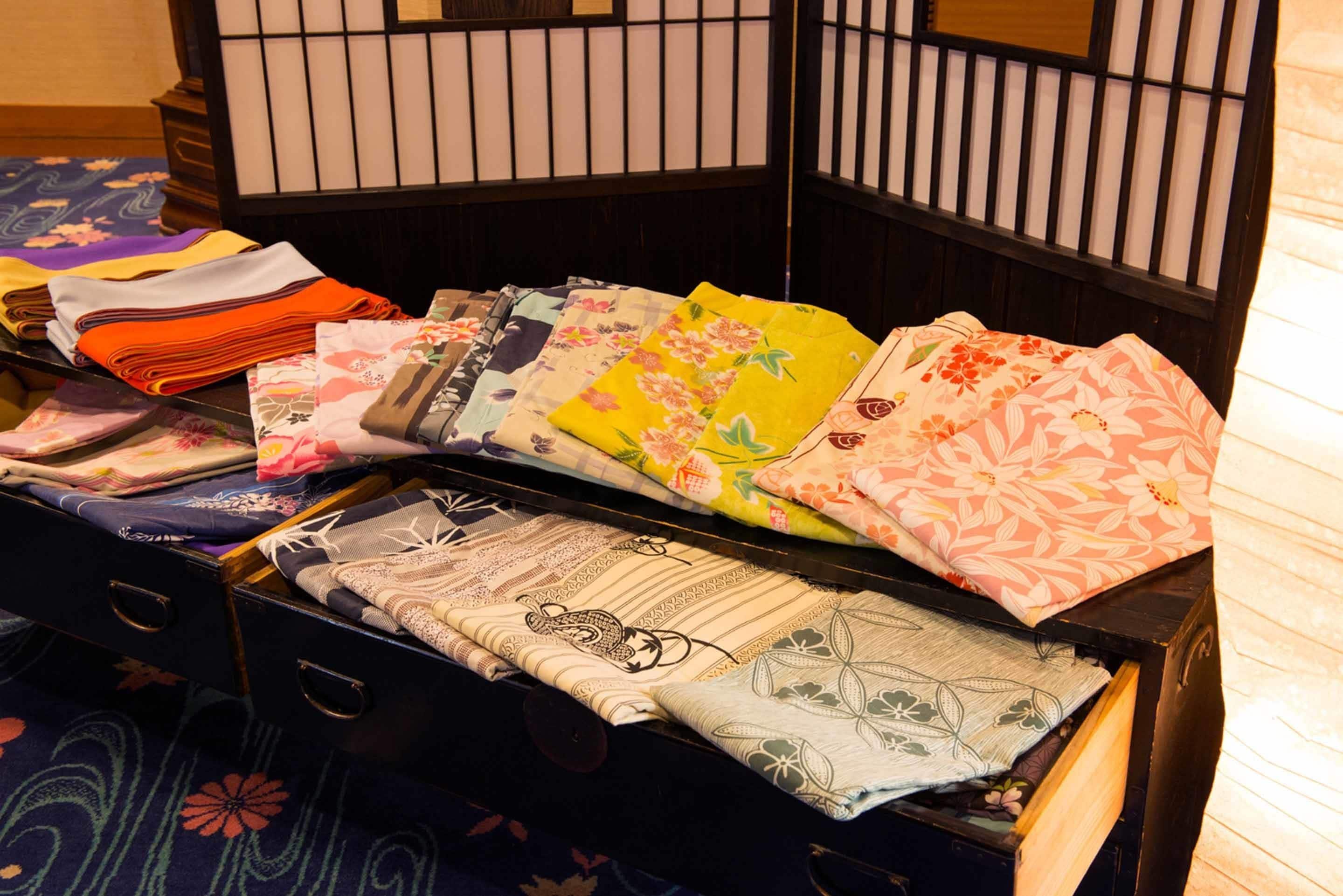 A traditional Japanese room with tatami flooring, a low wooden bed with a dark headboard, and a shoji screen in the background.