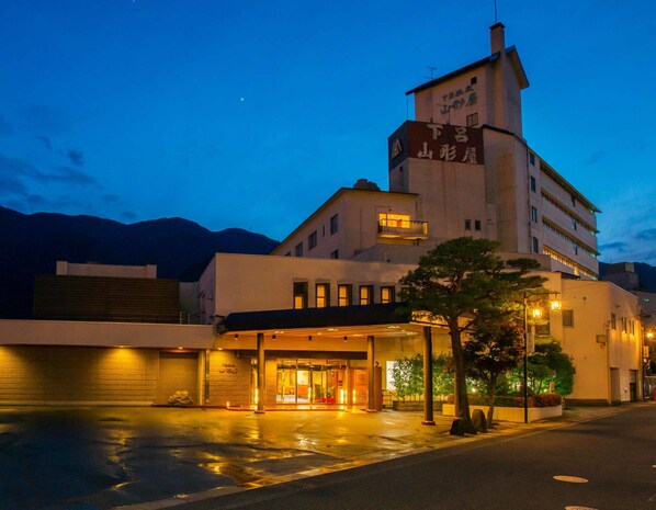 Un hôtel doté d’une tour imposante, d’une entrée abritée et d’un espace de stationnement.