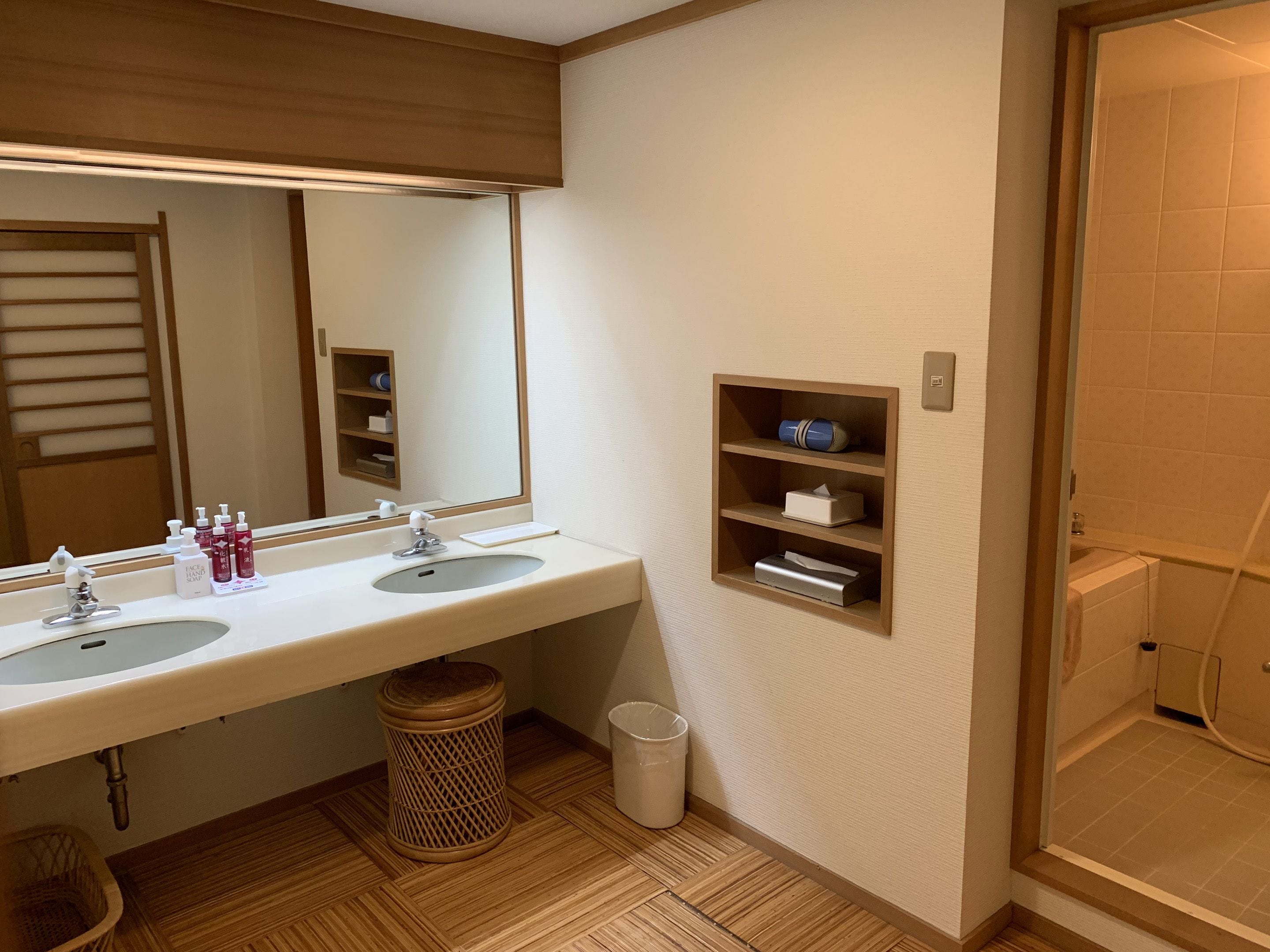 A bathroom with two sinks, a mirror, and a shower.