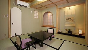 A traditional Japanese-style room with tatami flooring, a low table, and shoji screens.