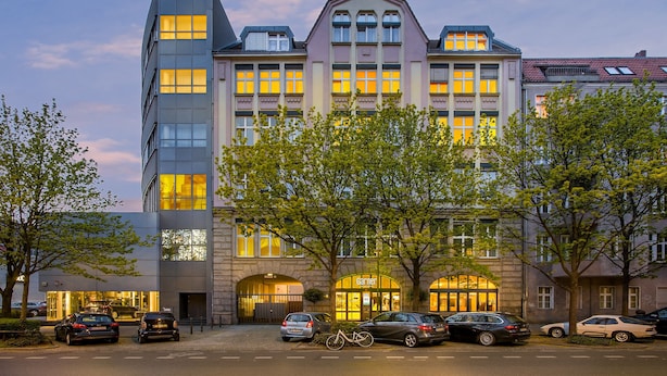 Un hôtel moderne, doté de nombreux étages, de grandes fenêtres et d’une entrée imposante.