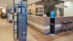 Un espace d’accueil moderne, doté d’un kiosque numérique fournissant des informations, de sièges et d’un répertoire des marques d’hôtels.