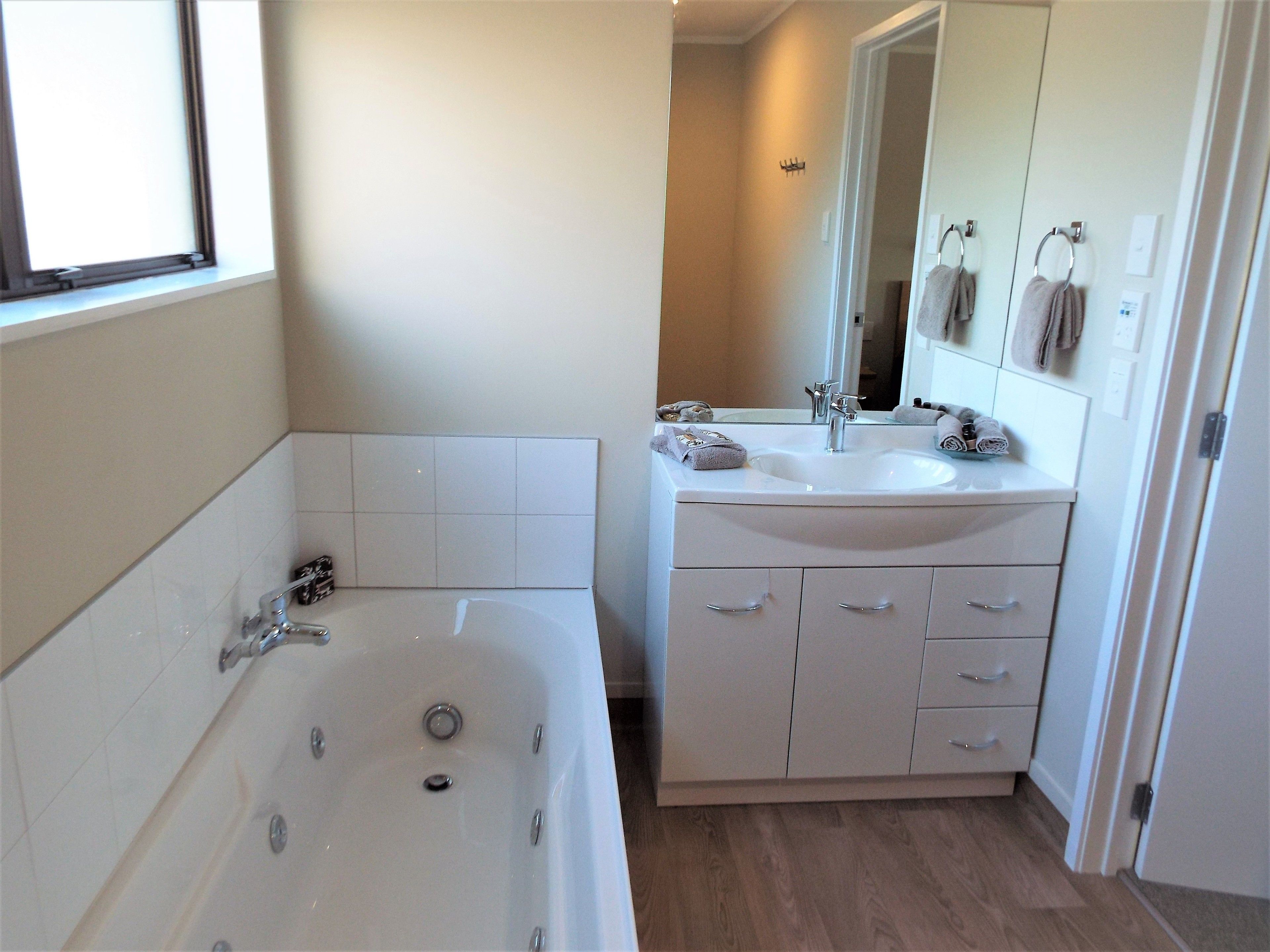 A modern bathroom with a bathtub, a sink, and a mirror.