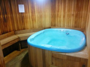 A wooden sauna with a blue bathtub.