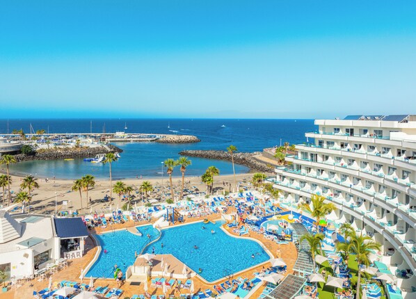 Een buitenzwembad, parasols voor strand/zwembad