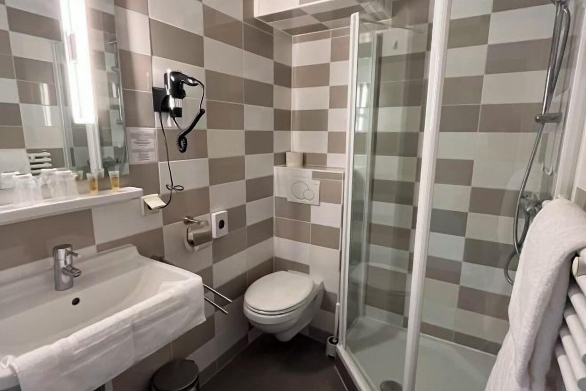Un baño con lavabo, inodoro y cabina de ducha de cristal.