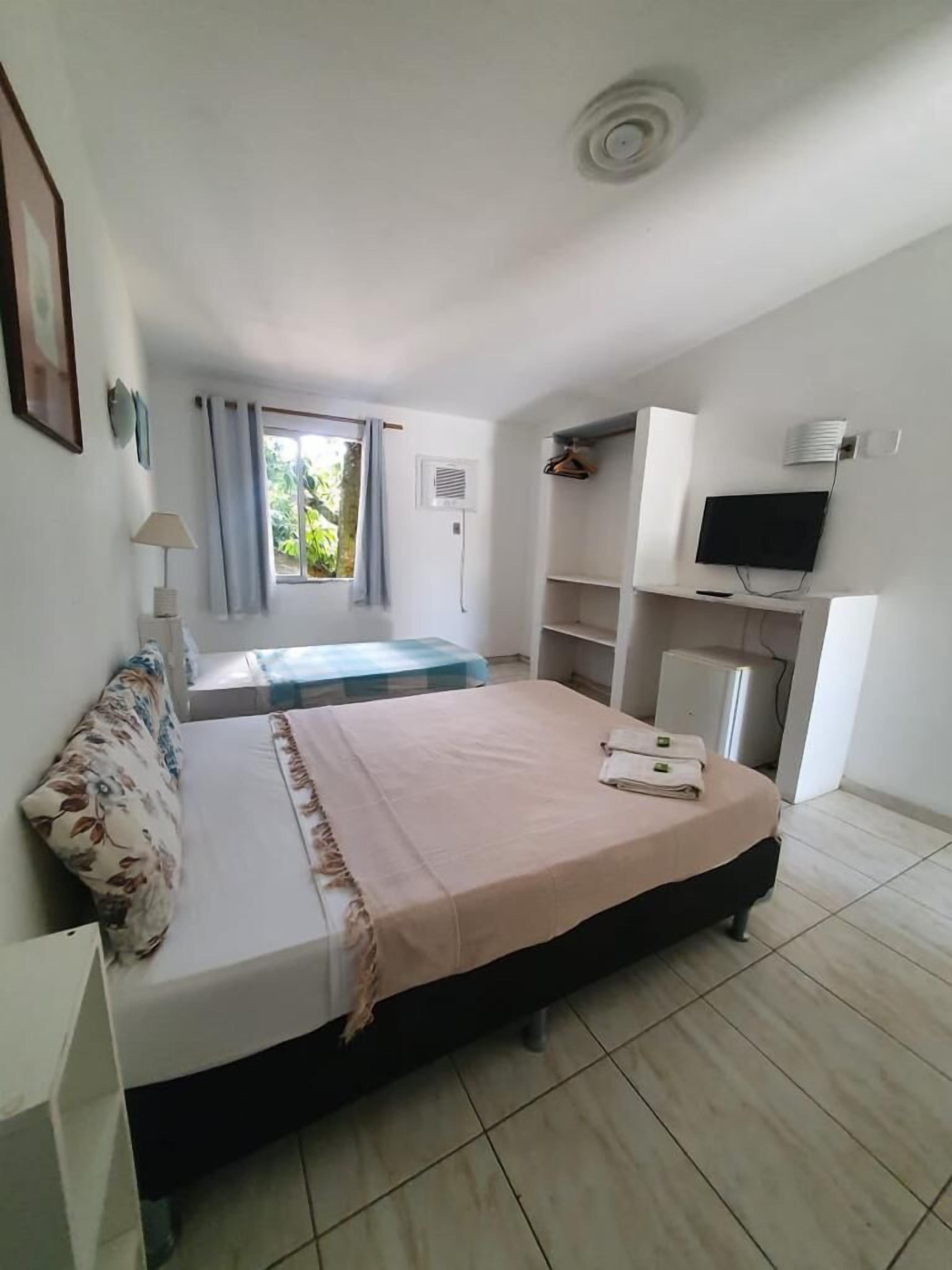 Habitación triple económica | Cortinas opacas, camas supletorias, wifi gratis y ropa de cama