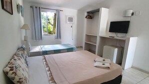 Une chambre à coucher avec un lit, une télévision, un bureau et une fenêtre.