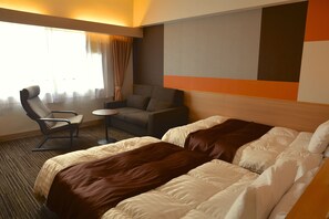 Une chambre d’hôtel avec deux lits, un canapé, une chaise et une petite table.