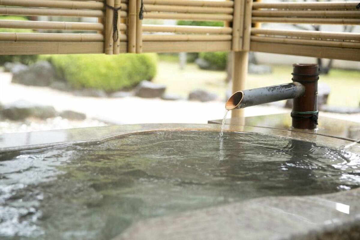 A bamboo structure with a water spout.