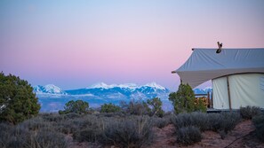 A tent with a view of snow-capped mountains in the background.