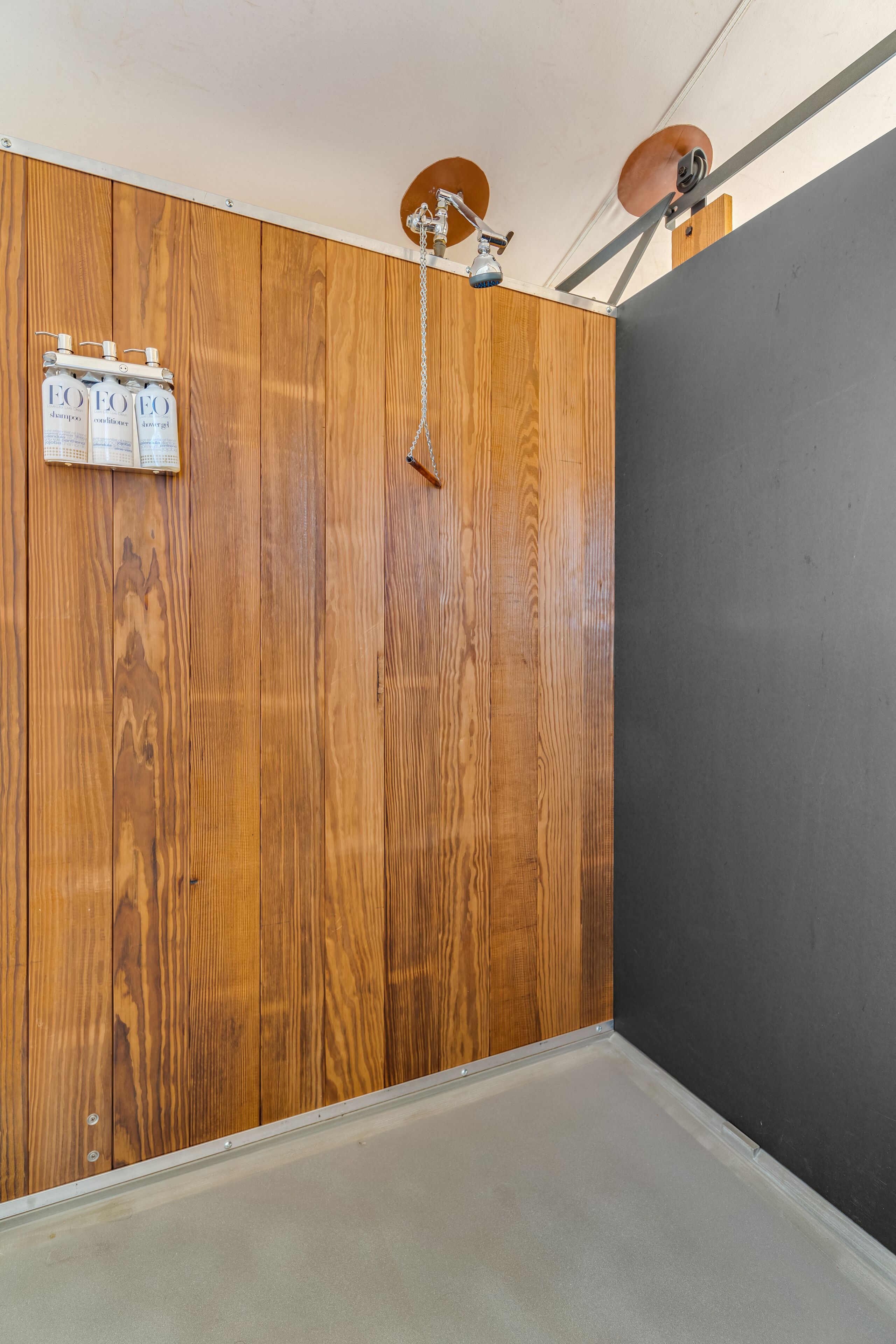 A room with a wooden panel wall, a grey wall, and a white ceiling.