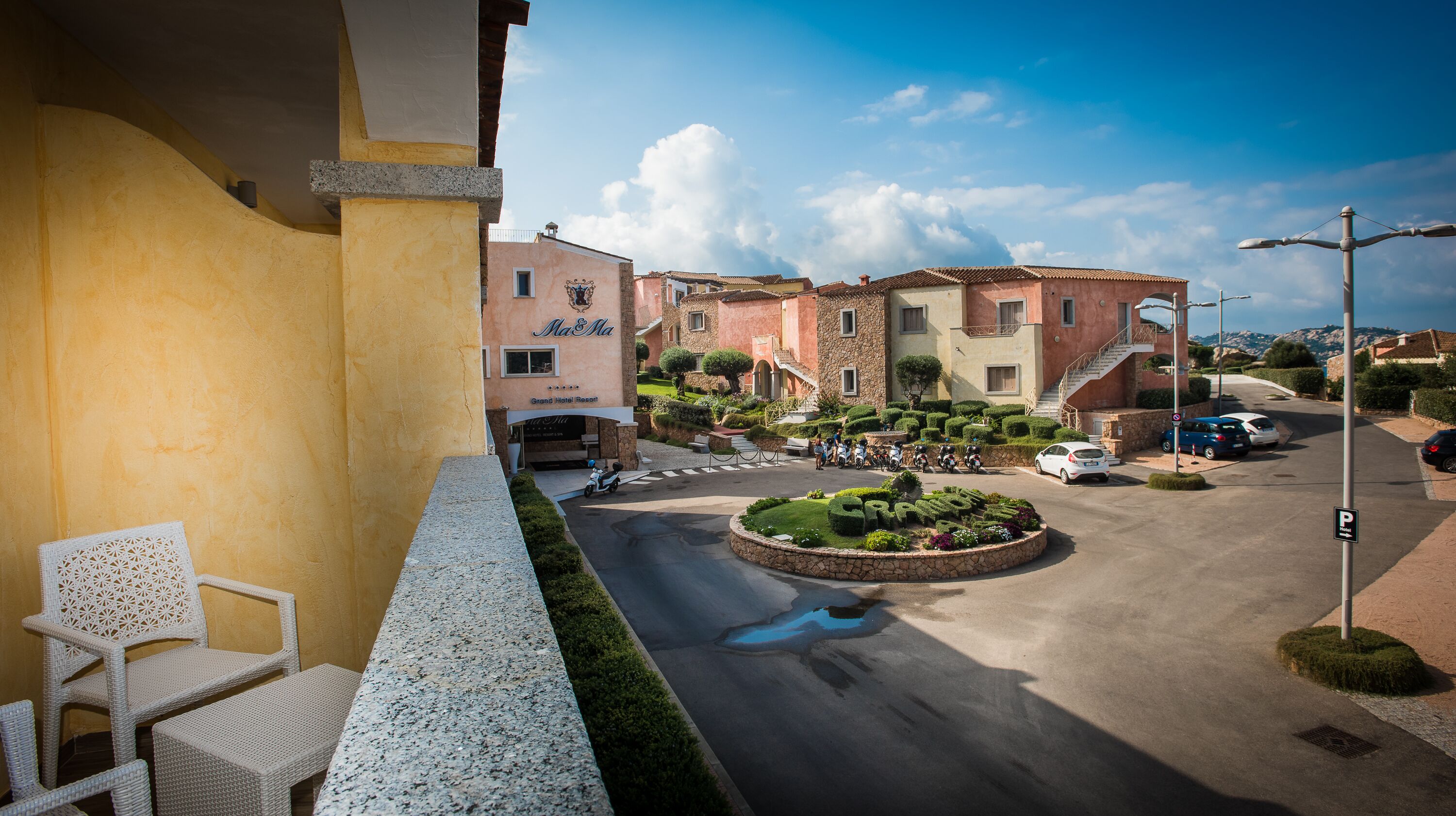 A hotel with a courtyard, outdoor seating, and a view of the street.