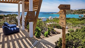 Um deck de madeira com uma placa de recepção, um bar de praia e um sinal de banheiro e chuveiro.