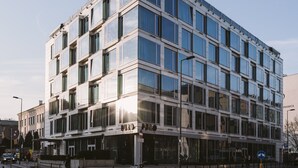 A modern multi-story building with large windows and a flat facade.
