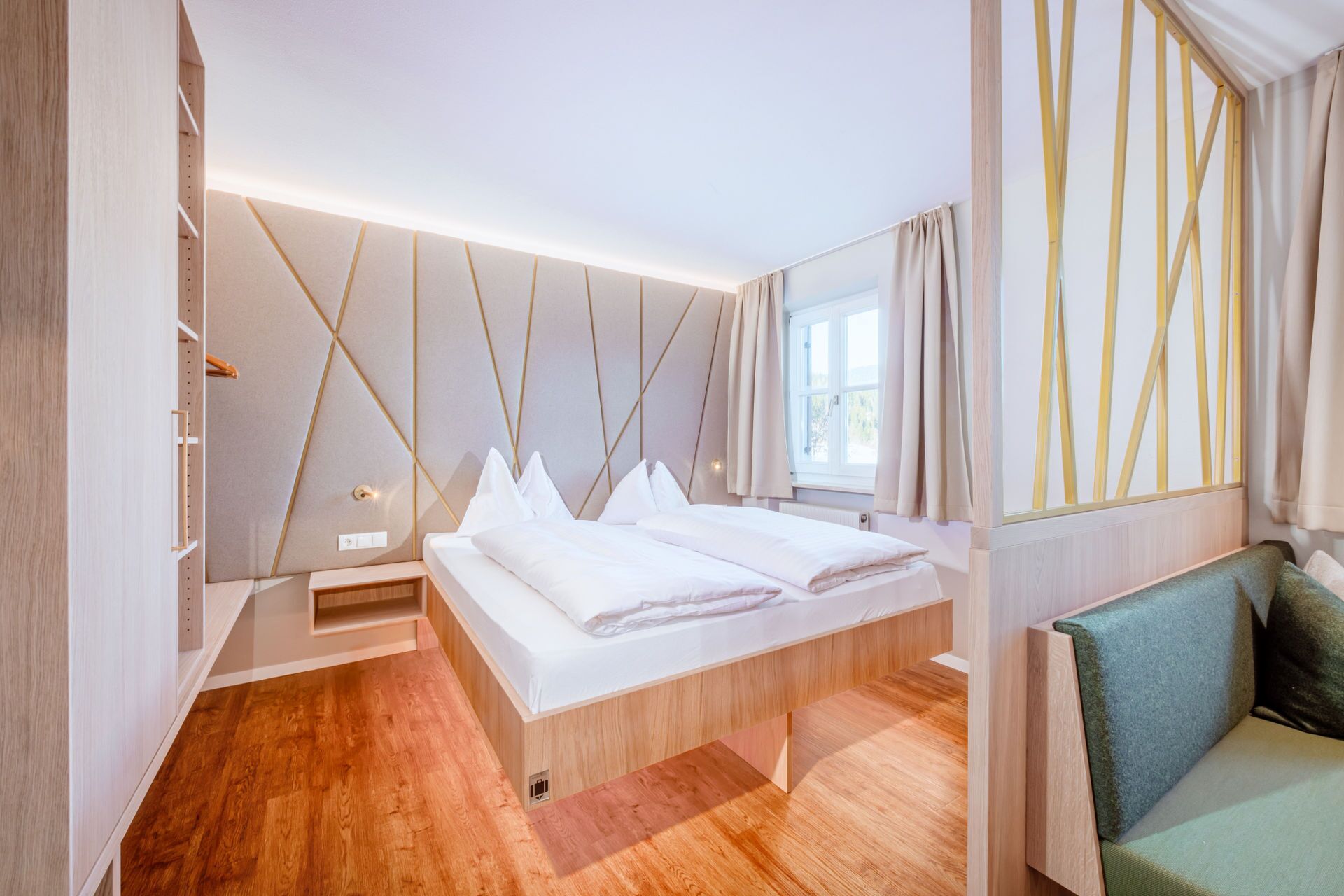 Un dormitorio moderno con una cama de madera, un banco y una ventana con cortinas.
