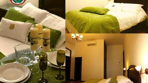 Una habitación de hotel con una cama bien hecha, un área de comedor con una mesa dispuesta para dos personas y una araña.