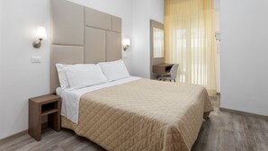 Una camera d'albergo moderna con un letto grande, comodini, una scrivania e una sedia.