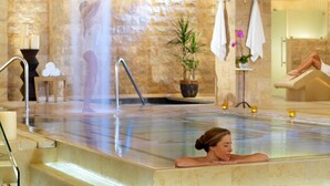 A spa area with a hot tub, a stone wall, and a potted plant. - NOBU Las Vegas – A Caesars Rewards Destination (Las Vegas)