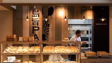 Una vetrina di panetteria con diversi prodotti da forno e uno chef che cucina.