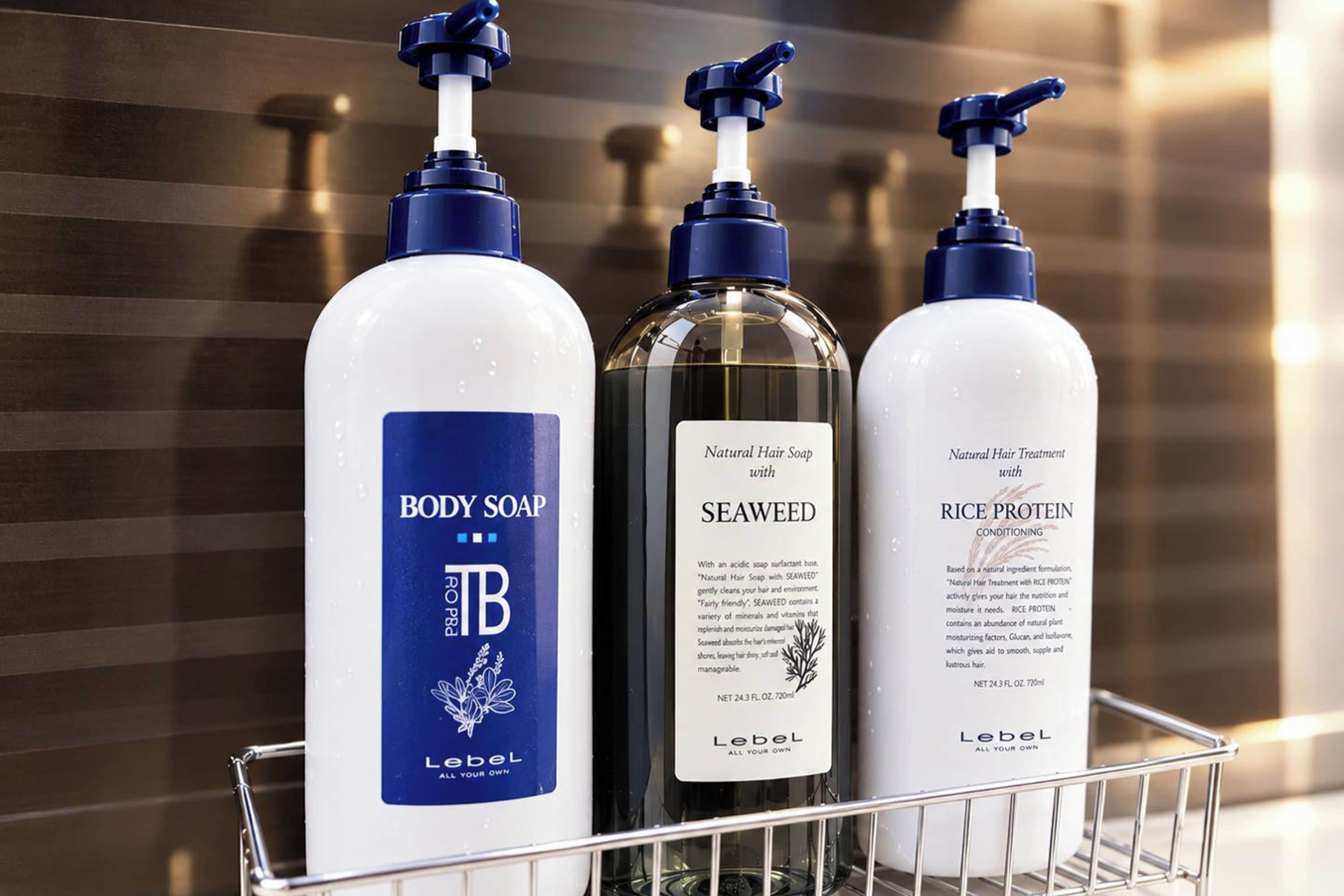 Three bottles of body soap in a metal basket.