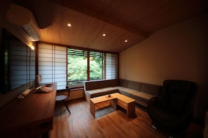 A modern living room with a wooden ceiling, a sofa, a coffee table, and a chair.